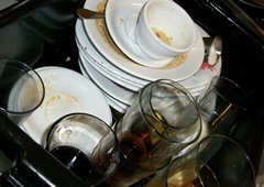 A pile of dirty dishes, cups, glasses