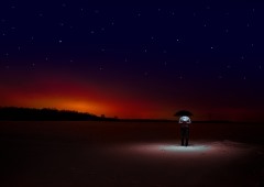 Night Man standing out in the night with an umbrella and a light
