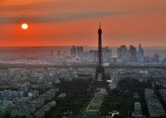 Eiffel Tower with sun in background and a view of Paris