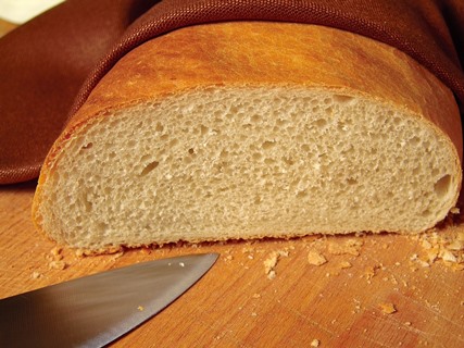 A loaf of bread which has been sliced, leaving crumbs